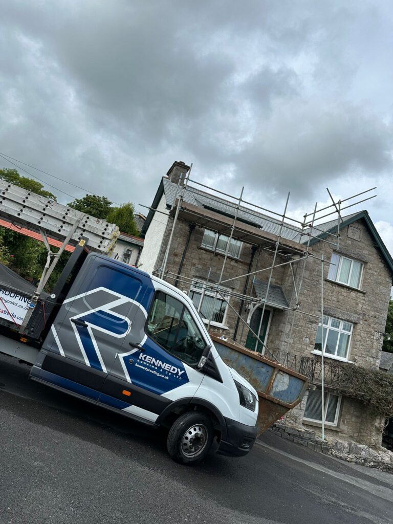A van outside a roof which has scaffold around it | Kennedy Roofing
