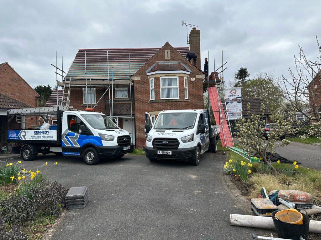 two vans outside a house | Kennedy Roofing